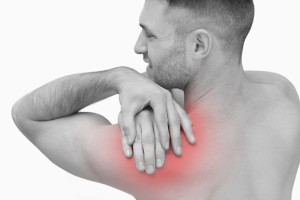Rear view of shirtless man with shoulder pain